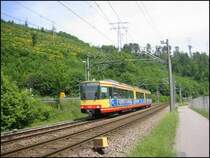 Stadtbahn-Triebwagen 575 ist am 15.05.2006 auf der Linie S11 zwischen Ittersbach und Karlsruhe-Neureut unterwegs. Die Aufnahme erfolgte auf dem Gebiet der Stadt Ettlingen, zwischen den Haltestellen Albgaubad und Spinnerei. Im Hintergrund sind die H�nge des Wattkopf zu sehen.