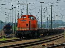 Locon 215 (203 141-7) steht am 30.05.2012 mit einem mit alten Holzschwellen beladenen Flachwagenzug in Aachen West.