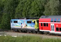 111 066 mit Biergarten-Beklebung schiebt den RE von Salzburg nach M�nchen, aufgenommen bei Bergen am 02.06.2012