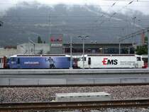 Ge 4/4 III 643 Vals  mit Ems Chemie Werbung und die Schesterlok 648 Susch  mit Swisscom Werbung sind aus St.Moritz eingetroffen und stehen hier am 11.07.2005 vor dem neuen Stellwerk Chur und dem vernebleten Calanda.