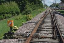 Weiche mit Stellhebel bei Karlsruhe/Neureut. Im Hintergrund die dann zweigleisige Hardtbahn der AVG nach Linkenheim/Hochstetten (S1/S11)