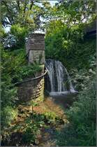 Vielleicht Deutschlands schrgster  Hauptbahnhof . Sieht nach botanischem Garten aus, ist aber das Portal des stlichen berlinger Tunnels in berlingen Mitte. Der Wasserfall ist die Tunnelrhre selbst. Der Bahnsteig beginnt bereits 10 m links des  Muerchens . Hier ist die Situation von unten: http://www.bahnbilder.de/bild/deutschland~triebzuege~br-650-regioshuttle-db/613567/vielleicht-deutschlands-schraegster-hauptbahnhof-ausser-zughalten.html