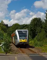 GTW 2/6 der Hellertalbahn kommt am 04.08.2012 von Betzdorf, sofort hinter dem Bahn�bergang ist der Haltepunkt Gr�nebacher H�tte. 
Einen freundlichen Gru� an den immer freundlichen Tf.  Die HellertalBahn - die sympathische Verbindung,  das ist der Slogan der Bahn, das ich auch einfach nur best�tigen kann.