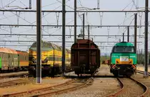 Vossloh Lok G2000BB von Railtraxx steht neben einem G�terwagen und dieser steht wiederum neben vielen alten belgischen 51er stehen in Montzen-Gare(B) bei knapp 40 Grad am 19.8.2012.