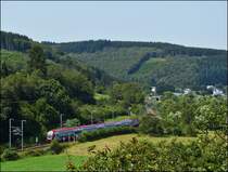 - Im Kiischpelt - In der br�tenden Hitze des 19.08.2012 durchf�hrt der IR 3739 Troisvierges - Luxembourg die kurvenreiche Strecke zwischen Enscherange und Wilwerwiltz. Diese Region im Norden von Luxemburg tr�gt den Namen Kiischpelt, welcher wahrscheinlich von dem deutschen Wort  Kirchspiel  abgeleitet ist. Dieser Name f�hrt auf die Tatsache zur�ck, dass im Mittelalter hier eine der wichtigsten Kirchen der Region, eine sogenannte Mutterkirche, stand. (Jeanny)