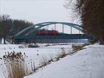 An einem tr�ben, kalten Wintertag passiert eine BR 145 mit leeren Autotransportwaggons bei B�chen die Br�cke �ber den Elbe-L�beck-Kanal in Richtung Boizenburg; 20.02.2010
