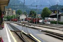 Bahnhof Meiringen 2005. In Verl�ngerung des Gleises Richtung wei�e Hauswand, dort wo der Traktor Tm 598 und der Montagewagen X 9757 stehen, fahren heute die Z�ge der MIB ab. Fr�her war die Haltestelle der MIB (Meiringen Innertkirchen Bahn) hinter dem Bahn�bergang an dem wei�/blauem Schild. Das linke Bahnareal mit den 3 Traktoren und der Drehscheibe ist heute ein Parkplatz. (23.07.2005)