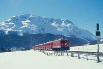 RhB Schnellzug 544 von St.Moritz nach Chur am 26.02.1998 bei Celerina mit E-Lok Ge 6/6II 702 - B - A 1241 - A 1228 - B 2391 - B 2377 - B 2358 - D 4216. Hinweis: gescanntes Dia
