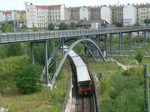 S-Bahn der BR 481 in der sog. Ulbrichtkurve. Diese wurde 1961 errichtet, um die Bahnh�fe Sch�nhauser Allee und Bornholmer Stra�e miteinander zu verbinden, was nach der Trennung der beiden Berliner S-Bahnnetze durch den Mauerbau notwendig wurde. Der hier zu sehende Verlauf entspricht nicht mehr dem urspr�nglichen Verlauf. Dar�ber eine Fu�g�nger- und Fahrradbr�cke Richtung Mauerpark. 16.7.2006