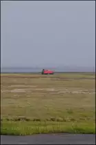 Vom Damm aus hat man einen guten Blick auf die Wangerooger Salzwiesen und das Wattenmeer und auch auf die kleine 399 107-2. Die Loknummer ist zwar kaum zu erkennen, aber 399 107 und 108 sind unterschiedlich gedreht; 399 107 Richtung Hafen; 399 108 Richtung Inseldorf. (28.08.2012)