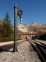 Wasserkran auf dem Bahnhof Gletsch der Furka-Bergbahn am 2.10.2011, dahinter das Blauhaus der DFB.