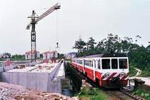 W�hrend die Z�ge noch �ber die alte Ave-Br�cke von 1875 bei Vila do Conde rumpeln (Hier: 9613+9604), entsteht daneben schon eine moderne Betonkonstruktion. Der Neubau ist im Hinblick auf k�nftige Ausbaupl�ne schon f�r zweigleisigen Betrieb ausgelegt (13. Mai 1988). 