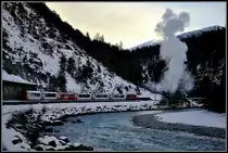 GlacierExpress 910 mit Ge 4/4 II 613  Domat/Ems  kreuzt in Trin den Dampfextrazug nach Valendas-Sagogn. (15.12.2012)