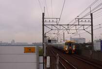 Serie 257: Im dunstigen Abendlicht verlässt ein Zug der Serie 257-500 den Grossraum Tokyo Richtung Bôsô-Halbinsel. Ichikawa Shiohama, 22.November 2009. 