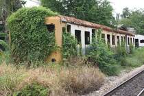 Auch ein Steuerwagen mit der noch lesbaren Nummer 2 verrottet etwa 1,5 Km ausserhalb des Bf. Mahachai. Bild vom 24.Juli 2012. 

