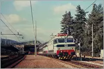 Ohne Halt fährt der EC Genève - Milano in Arona durch. 
Neben der Doppeltraktion mit der 632 049 an der Spitze und einer 444, fällt der in SBB-IC Lackierung gestaltete erste BmUIC-Z1 (heute Bpm 50) Wagen auf.
Fotografiertes Foto, Oktober 1985