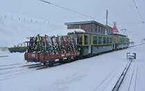 BDeh 4/4 Pendel 117 mit einem Skiwagen bei Einfahrt aus Grund in Kleine Scheidegg. Trotz des sehr schlechten Wetters, und obwohl die meisten Skilifte abgestellt waren (Sturm), bentigte es trotzdem die Zusatzzge, 01.02.2013.