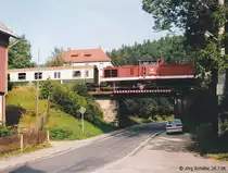 Die „Oberlandbahn“ f�hrt von Norden her am Waldhang entlang ins Tal nach Ziegenr�ck hinab. Kurz vor dem Bahnhof �berquert sie noch diese Br�cke. (204 869 am 26.7.95)
