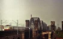 Eine 103 f�hrt im Sommer 1980 �ber die Rheinbr�cke D�sseldorf-Neuss. Rechts sind die Reste der nach der Zerst�rung im 2. Weltkrieg nicht wieder aufgebauten s�dlichen Br�cke zu sehen.