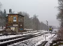 Und wieder, wie mein Freund Stefan es nennt, l�sst der Winter seinen Abfall fallen - 

Ein Stadler GTW 2/6 (VT 118) der Hellertalbahn f�hrt am 17.03.2013, bei Schneefall, von Herdorf weiter in Richtung Neunkirchen. 

Links ist das 1901 gebaute Stellwerk Herdorf Ost (Ho).