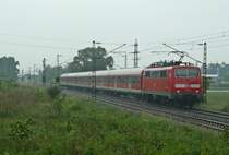 111 061 mit einer RB nach Offenburg am verregneten 24.05.12 kurz vor dem Halt in Buggingen. Im Bahnhof steht 146 114-4 mit dem Gegenzug nach Neuenburg (Baden).