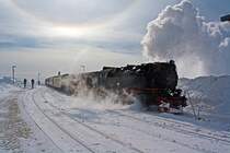 Bei sehr starkem eisigen Wind, mir starken Schneeverwehungen f�hrt am 23.03.2013 die 99 7247-2 ex DR 99 247 (eine Neubaulok) mit ihrem Regelzug der HSB in den Brockenbahnhof (1.125 m �. NN) ein.