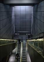 Hier gut erkennbar die Tiefe der U-Stationen. Im Gegensatz zu vielen anderen Städten, wurden in Kopenhagen die Bahnhöfe als ein einziger Hoher Raum ausgeführt, ohne durchgehende Zwischendecken. Schön der Lichteinfall durch die Oberlichter. Vielleicht hätte man für jede Station ein anderes Material für die Wandgestaltung aussuchen sollen, um der jeweiligen Station ein eigenes Gepräge zu geben. Ob der vorherrschende Grauton auf die Dauer das Wahre ist, bleibt zu bezweifeln. Trotzdem sind die Stationen von der Raumwirkung sehr gelungen. 

23.08.2006 (M) 