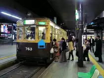 Die ältesten Strassenbahnwagen von Hiroshima - die Wagen aus Ôsaka, Serie 751: Der Fahrer des Wagens 763 hat den Führerstand gewechselt und die vordere Türe nun zum Einsteigen geöffnet. Die Fahrgäste werfen beim Einsteigen entweder den Einheitpreis in den Kasten oder buchen die Fahrt elektronisch auf dem Lesegerät ab. Hiroshima Bahnhof, 28.Februar 2009. 