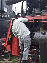 Ein Mechaniker kontrolliert und lt die BR 23 1019 beim Halt in Sulechw (27.04.2013).
