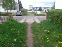  Es f�hrt kein Zug nach Nirgendwo.  Gleisreste in einer Stra�e. Der Weg dahinter die ehemalige Trasse (Nordhausen 09.05.2013)