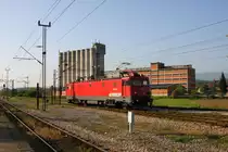Serbien - Bahnhof Pozega 
Die sechsachsige 461-006 Elektrolok rangiert vor einem m�chtigen Silo
und setzt sich am 4.5.2013 vor einen G�terzug, der hier von Diesel auf
Elektro umgespannt wurde.