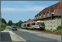 S�dlich des Bahnhofs Ottendorf-Okrilla Nord rollt 642 339 der St�dtebahn Sachsen gem�chlich Richtung Dresden. Hier verl�uft die Strecke direkt neben der Hauptstra�e durch den Ort, zahlreiche kleine Bahn�berg�nge sind zu passieren. (17.06.2013)