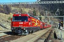 RhB Schnellzug 560 von St.Moritz nach Chur am 26.02.1998 in Filisur mit E-Lok Ge 4/4 III 648 - B - A 1272 - A 1281 - B 2392 - B 2381 - B 2425 - D 4215. Hinweis: Lok noch mit alter Werbung: VEREINA, gescanntes Dia.
