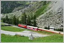 R235 nach Zermatt mit der HGe 4/4 II 4  T�schhorn  an der h�chsten Stelle der Umfahrungsstrecke, davor die neu angelegte Strasse. Neben dem Bergsturz, ist auch der Dorfbach von Randa eine st�ndige Gefahr, weil er bei Gewittern oft als Mure zu Tal donnert. Die Stahtr�gerbr�cke im Bild wird n�chstens durch einen Neubau ersetzt. (04.08.2013)