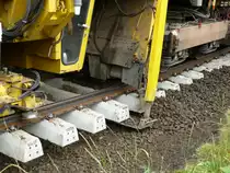 Schotterbettreinigungsmaschine im Einsatz, der alte Schotter durchl�uft eine spezielle Reinigung im mitgef�hrten Wagen und wird anschlie�end wieder unter und neben dem Gleisk�rper verteilt, diese Vorrichtung schiebt mittels einer  Schaufel  den Schotter unter die Schwellen, BSB-Strecke Gottenheim-Hugstetten, Aug.2013