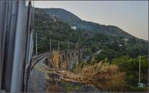 <U>Capo Vaticano.</U>

An der Fußspitze des Stiefels stellt sich bei Vibo Valetia noch ein Gebirgszug der Bahn in den Weg. Der muss aufwendig via Capo Vaticano umfahren werden. Viele Fiume (Canyonartige Schluchten) müssen überquert werden. Hier mit einem schöne Viadukt bei Ricardi. Im August 2013.