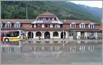 Der Bahnhof Interlaken-Ost spiegelt sich im flachen Wasser eines riesigen Brunnens. (06.07.2013)