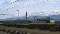 Vor der imposanten Bergkulisse der hohen Tatra f�hrt am 2.5.2003 Elektrolok
162007 mit einem OS aus Richtung Strba in den Bahnhof Poprad Tatry ein.