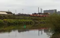 Der Herbst ziert sich noch an manchen Stellen - Zwei MRCE 185 ziehen ihren leeren Ganzzug durch das Saartal.
Der Zug kommt aus F�rstenhausen vom Kraftwerk Fenne.
Um diese Stelle hier zu erreichen mu� er zun�chst auf der anderen Saarseite in die genau entgegen gesetzte Richtung fahren, um beim Saarbr�cker Schanzenberg die Saar zu �berqueren.
Die beiden 185er bringen ihren Zug nun Saar abw�rts in Richtung Ruhrgebiet um Nachschub zu holen.
Hier passieren sie gerade das Brammenlager der Saarstahl in V�lklingen.
Bahnstrecke 3230 Saarbr�cken - Karthaus
21.10.2013