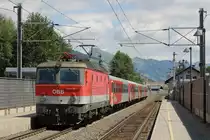 1144 221 mit REX 1506 Salzburg Hauptbahnhof-W�rgl Hauptbahnhof auf Bahnhof Brixen im Thale am 31-7-2013.