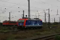 Die Werbelok 482 037-9 ``Infraleuna`` der SBB Cargo stand am 17.10.2013 im Bahnhof Gro�korbetha, daneben steht eine BR 155. Im Hintergrund sieht man gut die Gasflamme der Leuna-Werke.