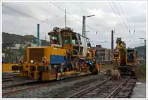 Im Einsatz am 20.10.2013 auf der KBS 440 (Ruhr-Sieg-Strecke) in Siegen-Geisweid beim B� 101 in km 100,713. Die Plasser & Theurer Schnellschotterplaniermaschine SSP 110 SW  (Schweres Nebenfahrzeug Nr. 97 16 46 516 18-9) der DGU - Deutsche Gleisbau Union (Koblenz). 

Der Schotterpflug wurde 2007 unter der Fabriknummer 840 gebaut. Die EBA-Nr. ist EBA 04 809 B017.

Technische Daten:
Spurweite: 1.435 mm 
Anzahl der Achsen: 2 
Achsabstand: 8.100 mm 
L�nge �ber Puffer: 17.230mm 
Eigengewichtbetr�gt: 44
H�chstgeschwindigkeit bei Eigenfahrt: 100 km/h 
Motorleistung: 400 kW  (Deutz BF8M 1015C Motor)  
Kleinster befahrbarer Radius: 120 m
Anh�ngelast: 40 t
Zur Mitfahrt zul. Personen: 3
zugelassene Streckenklasse : D 4

Die Schotterverteil- und Planiermaschinen SSP 110 SW stellen den erforderlichen Regelbettungsquerschnitt in Gleisen und Weichen her. 
Die Maschinen verf�llen, planieren und kehren das Gleis.
Sie verf�gen �ber Besenwellen f�r alle Oberbauformen. Diese Maschine hat ein Steilf�rderer der �bersch�ssiger Schotter in das Silo f�rdert,  woraus der Schotter bei Bedarf dem Gleis dosiert wieder zugef�hrt wird. 