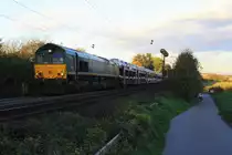 Die Class 66 PB14 von Railtraxx BVBA kommt mit einem langen Fiat-Autozug Tychy (PL) nach Antwerpen(B) von Aachen-West und f�hrt die Gemmenicher-Rampe hoch nach Belgien. Aufgenommen am Gemmenicher-Weg in der Abendsonne und Wolken am Abend vom 30.10.2013.