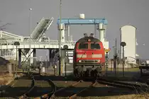 218386 ist am 12.2.2014 mit einem Ersatz IC nach Kopenhagen in Puttgarden auf
Fehmarn angekommen und setzt vor dem geschlossenen Hafentor um, um den IC wieder 
in Richtung Hamburg zu bespannen. Die Fahrgäste mussten an diesem Tag zu Fuß auf das Fährschiff gehen und konnten erst ab Dänemark wieder im Zug sitzen.