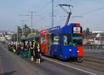 BVB während der BASLER FASNACHT 2014. Obschon während  den drey schenschte Dääg  nicht alle Linien auf den gewohnten Strecken verkehren, kommt es sehr oft zu Begegnungen zwischen Fasnachtscliquen und der BVB. Be 4/4 490 (Linie 6) mit Vollwerbung für den FCB und die GUGGENMUSIK  NUGGI SPUGGER  auf der Wettsteinbrücke am 11. März 2014.
Foto: Walter Ruetsch 