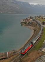 Den zwischen Tiefenwinkel und M�hlehorn einspurigen Streckenabschnitt am Walensee bef�hrt eine Re 460 mit ihrem 15 Wagen langen EC 206 auf der Fahrt von Chur nach Basel (16.03.2014).