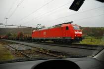 BR 185 117-9. Der G�terzug mit seiner feuerroten Lok durchf�hrt das Fricktal im Kanton Aargau/Schweiz. Bei diesem Regenwetter bleibe ich lieber bequem im Auto sitzen, damit Kamera und ich trocken bleiben. Nat�rlich mu� man erst eine geeignete Stelle zum Parken finden. Den Fensterrahmen habe ich bewu�t mit ins Bild  hereingenommen. 4.12.2006