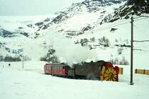 RhB Dampfschneeschleuder-Extrazug f�r GRAUB�NDEN TOURS 4454 von Alp Gr�m nach km 24,000 am 01.03.1997 oberhalb Alp Gr�m mit Dampfschneeschleuder X d rot 9213 - Triebwagen ABe 4/4 II 48.
