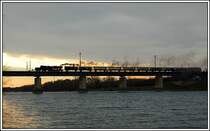 Anl�sslich der Feiern zum 100 Jahrjubil�um der Landesbahn am 9.12.2006 wurde von Wien aus die Tour O 16 der �BB Nostalgie nach Mistelbach Lokalbahn in Verkehr gesetzt. Wegen eines defekten Heizaggregates im Dih musste ein Nachschiebe-Tfz gestellt werden, was in Wien bereits zu einer Abgangsversp�tung von ca. einer Stunde gef�hrt hat. Die Aufnahme zeigt den Sonderzug 16760 bespannt mit 52.4984  Eberhard  bei der Querung der Donau in der Lobau. Ich habe mich in diesem Fall f�r eine Gegenlichtaufnahme entschieden, da meiner Meinung nach das Gegelicht eine wundersch�ne Stimmung erzeugt.