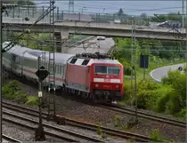 Der dunkle Himmel lässt es wie ein Gegenlicht aussehen, obwohl die Sonne eigentlich im Rücken wäre. 120 134-2 schiebt ihren IC richtung Tunnel der Neubaustrecke. Zuffenhausen, Mai 2014. 